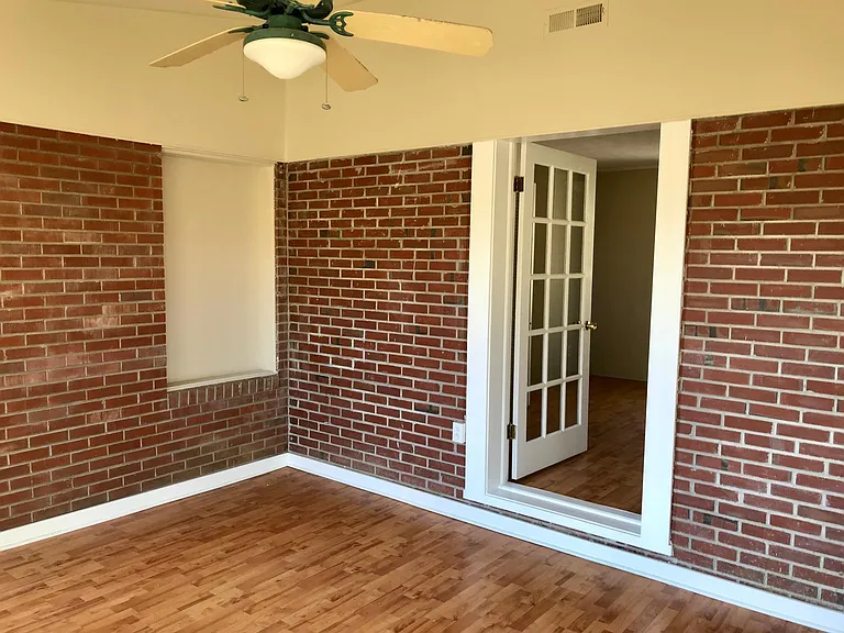 Office. Large room with sliding glass door exit to rear of the house. Large windows.