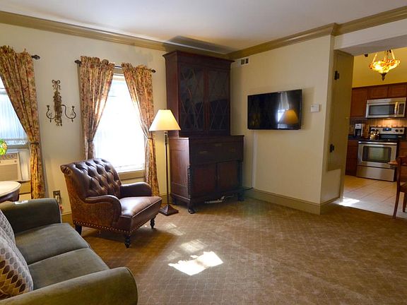 Living room with open kitchen area and large flat screen tel