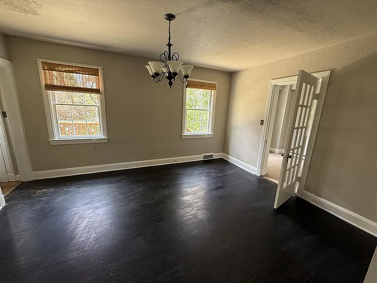 Large central dining area with adjacent office to the right. Half-bath, back door leading to deck and kitchen to the left.