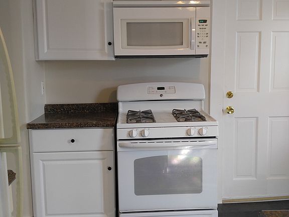 The kitchen has a gas stove, built-in microwave, a ceiling fan, and new vinyl flooring.