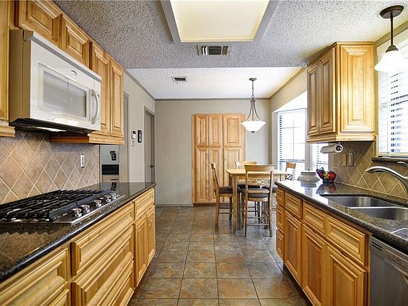 Distinctive replacement cabinets, granite  and gas cooking. See the large built in pantry straight ahead.
