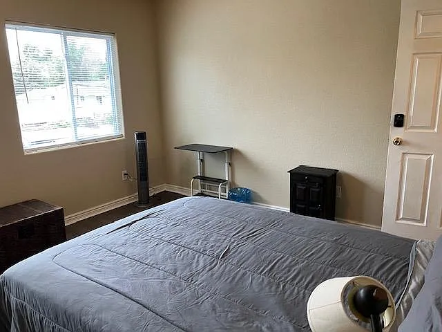 Bedroom offers a generous layout with 2 windows, neutral walls, and space for a bed plus a small work area.