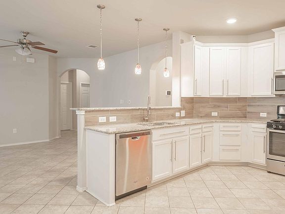 Open kitchen with bar counter and overhead hanging lights