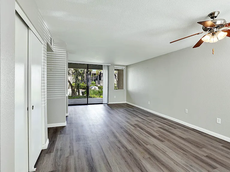 Lake Dianne Apartment Homes One Bedroom living and dining area with a ceiling fan and sliding glass doors.