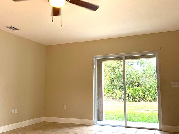 Family room w/ Ceiling fan and energy efficient SGD.