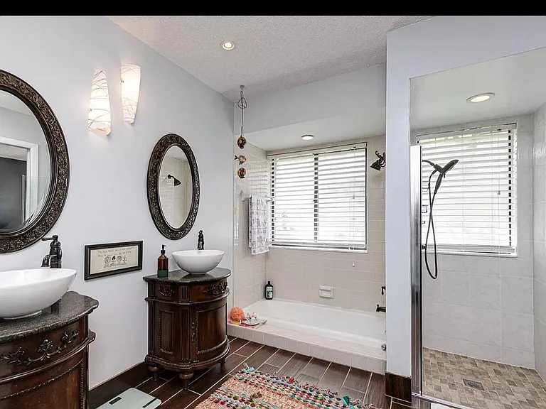 Master bathroom with two vanity, shower and separate bathtub.