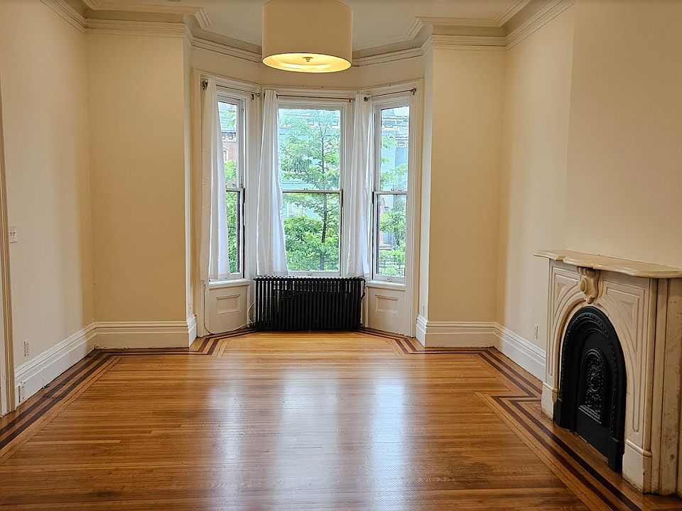 The sunny East-facing living room boasts 11' ceilings and magnificent views of the historic East End mansions.