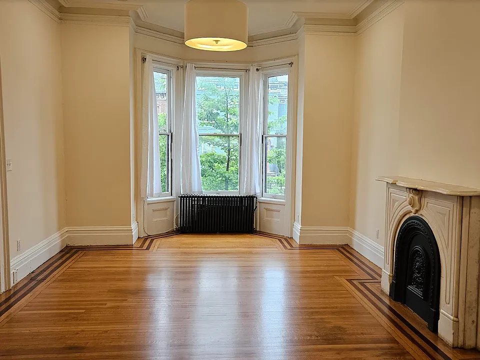 The sunny East-facing living room boasts 11' ceilings and magnificent views of the historic East End mansions.