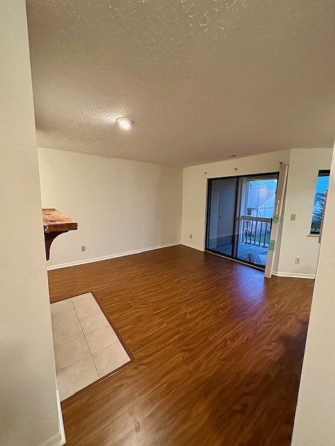 View of the living room from hallway to bedroom. Sliding glass doors to balcony.