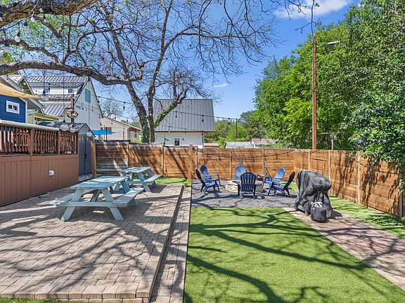 Picnic Tables and BBQ area under the shade of a Pecan tree. Hammock posts and mounts to left of fire pit.