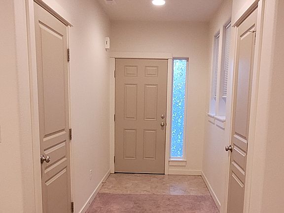 Front door and garage entry with coat closet on the right