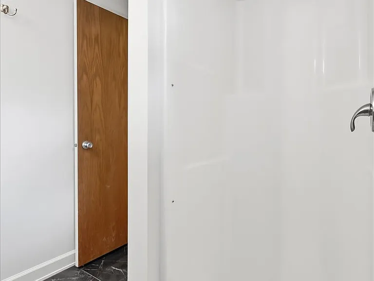 Fiberglass shower surround in lower level bathroom.