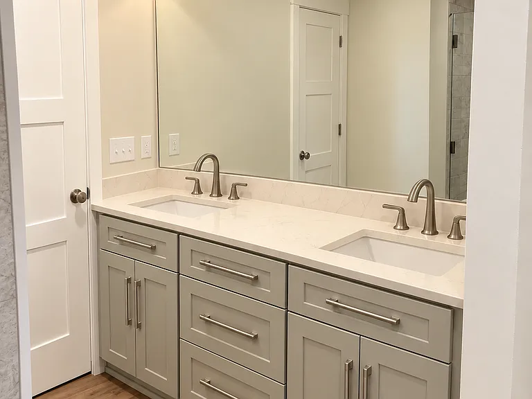 The spacious bathroom includes an expansive double vanity with a quartz countertop and ample storage that makes busy mornings a breeze while keeping essentials neatly organized.