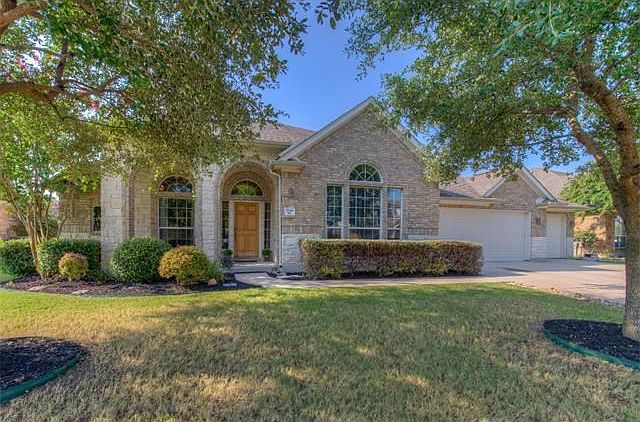 Gorgeous landscaping with two large trees out front.