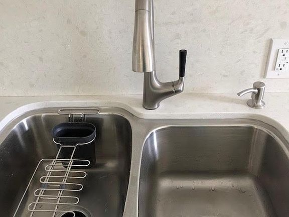Brand new kohler double sink and faucet equipped with a garbage disposl.