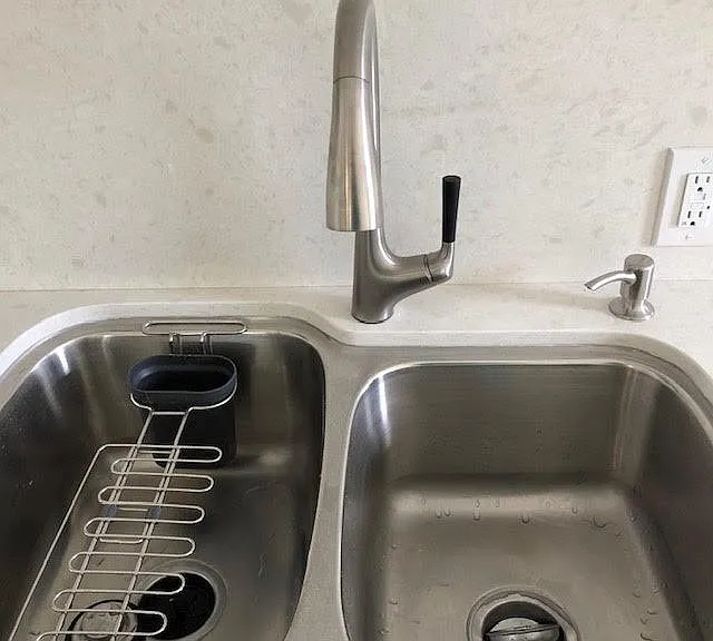 Brand new kohler double sink and faucet equipped with a garbage disposl.