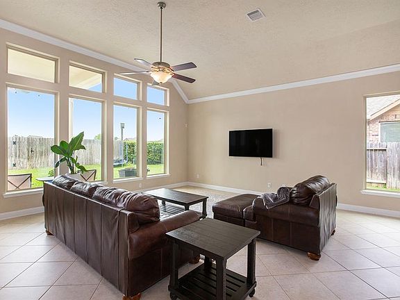 Spacious family room offers crown molding, tile flooring, ceiling fan and lots of windows!