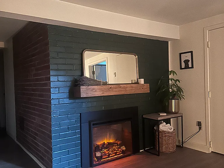 Living room with included electric fireplace and mantel. Fireplace features multiple flame settings and provides supplemental heat.