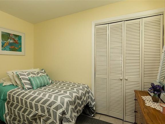 Small second bedroom (twin bed) with a large closet, small night stand and dresser.