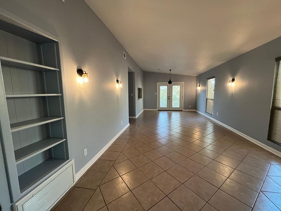 Living area with an area for a dining table. French doors lead to a deck