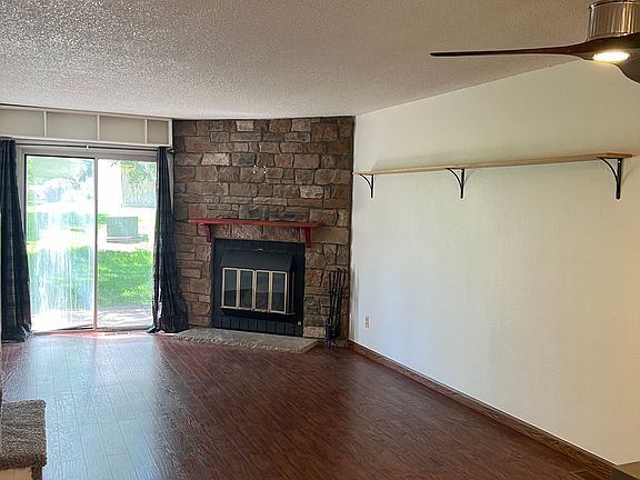 Laminate hardwood flooring with a decorative stone wall and sliding door to your back patio and greenbelt.