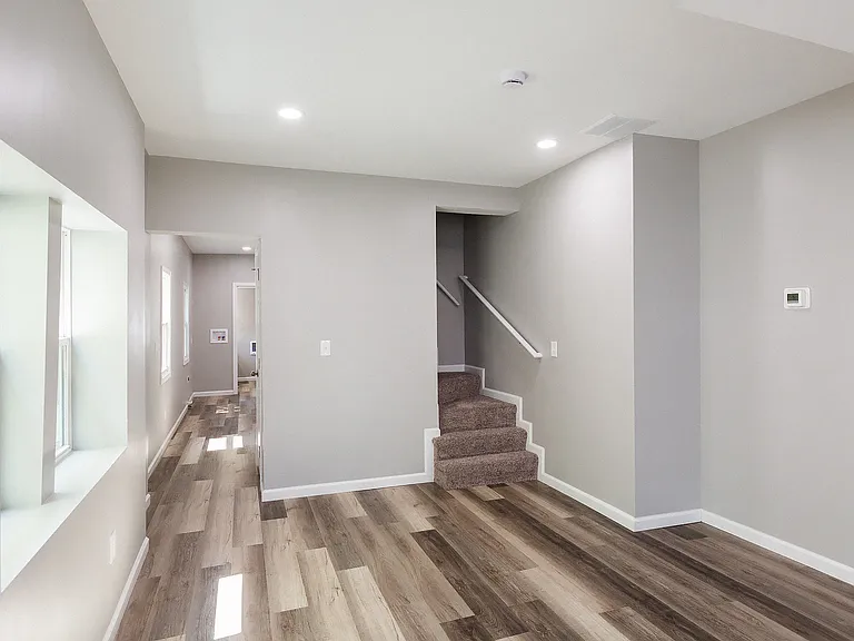 Living room, left hallway goes to basement and kitchen, right side is stairs to second floor.