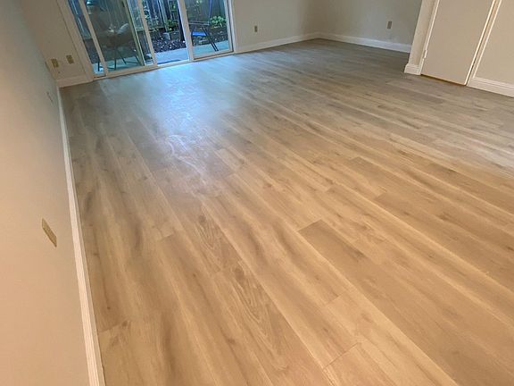 large living area with new vinyl plank floors, sliding doors to private patio
