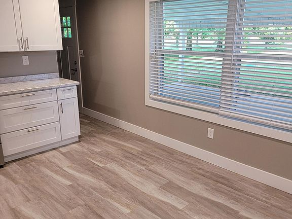 Large, well-lit eat-in kitchen area, overlooking back covered patio - featuring brand new Shaw waterproof vinyl plank flooring