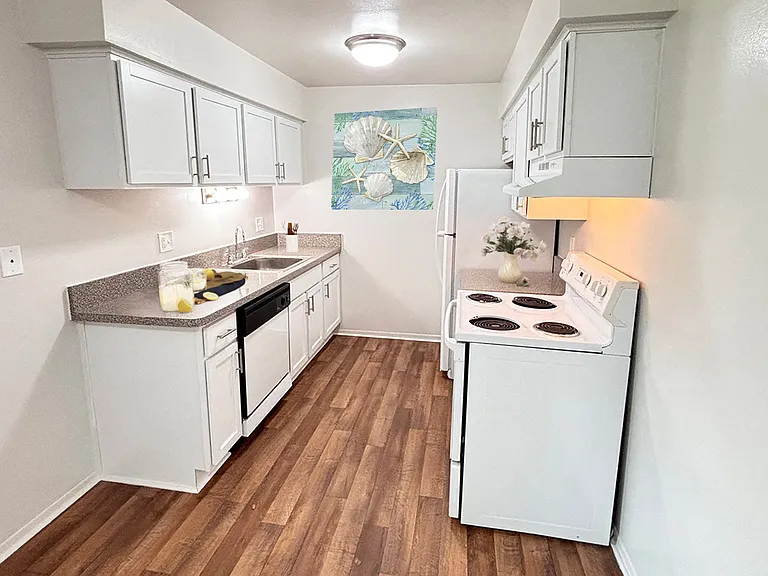 Newly upgraded kitchen with white shaker cabinets and granite look countertops along with easy care vinyl flooring.