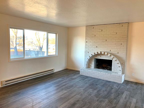 Spacious upstairs living room which boasts natural light. Complete with a fireplace. Home also has a downstairs living room with a fireplace and large window.
