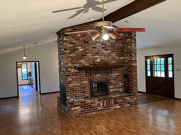 Entryway with huge double sided fireplace; kitchen seating area on one side / den with wet bar on other