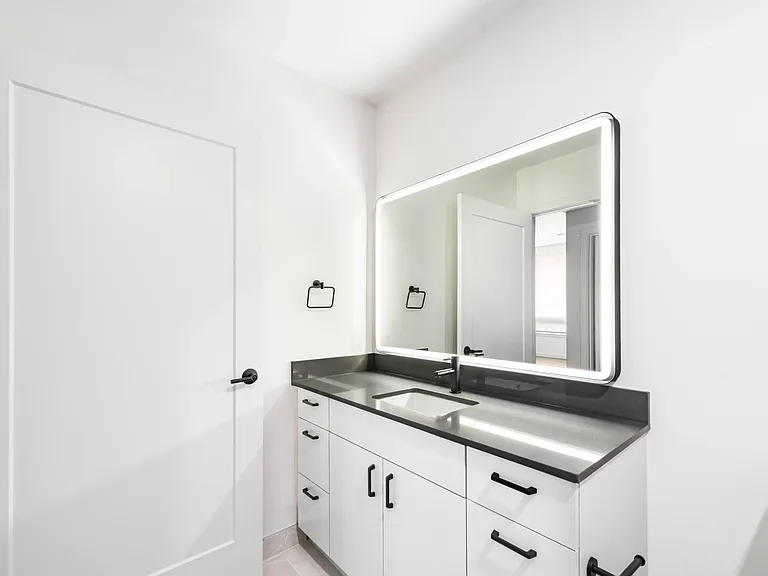 Bathroom vanity with a clean-lined sink, integrated lighting, and streamlined cabinetry creating a bright, functional space for daily routines.