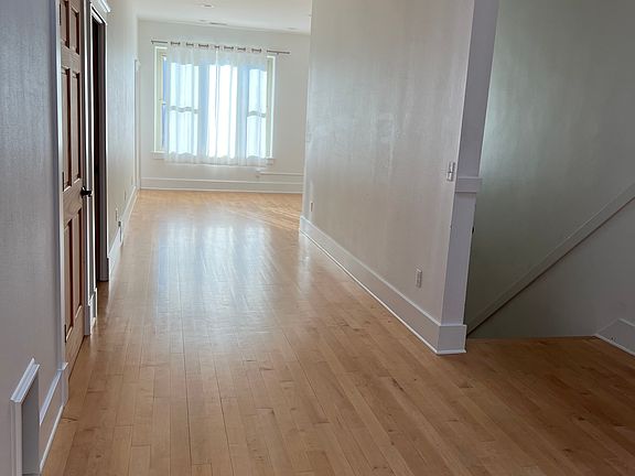 View at top of stairs facing east. Large living room area.