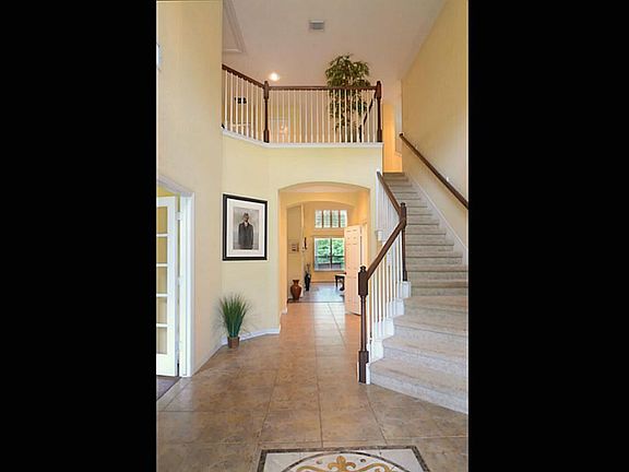 Guests enter this home to an impressive 2-story Foyer with designer, inlaid tile floors, tasteful crown molding, an angled staircase that provides interest and views of the lake that draw attention inward