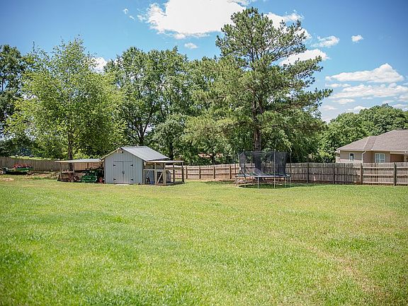 Fenced in yard with shop