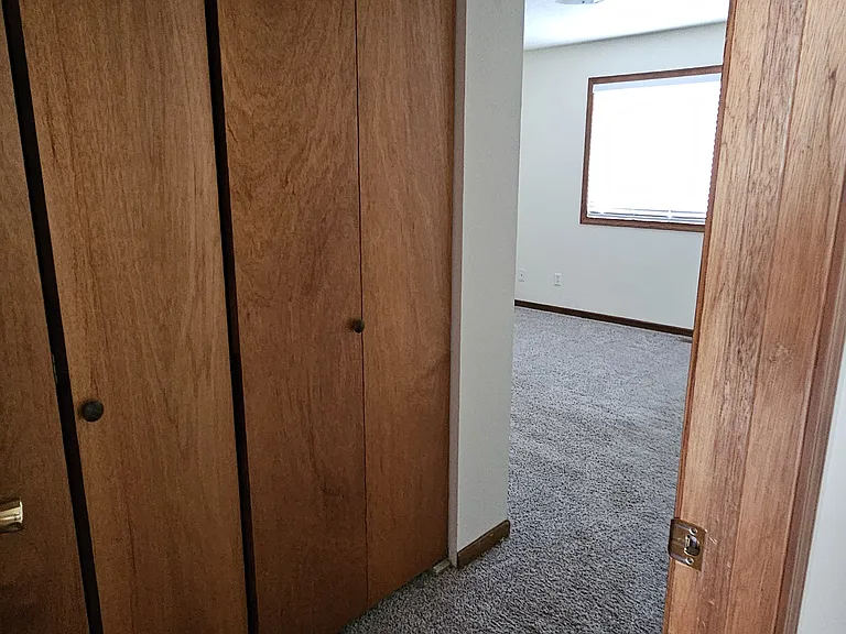 Primary bedroom offering large storage closets and en suite half bath.