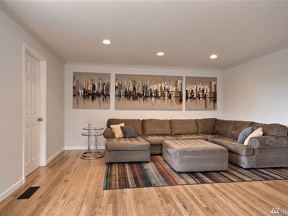 Living room w/ hardwood floors, crown molding & recessed lighting.
