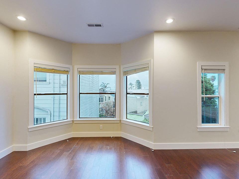 Living area with large windows and wood-like flooring