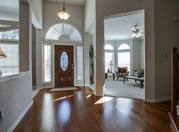 Elegant entry with soaring ceilings and wood floors.