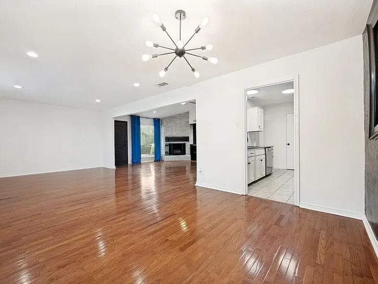 Spacious interior featuring wood-finish flooring, recessed lighting, and a modern sputnik chandelier