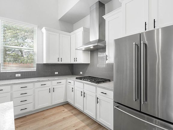 The kitchen has beautiful white cabinetry.