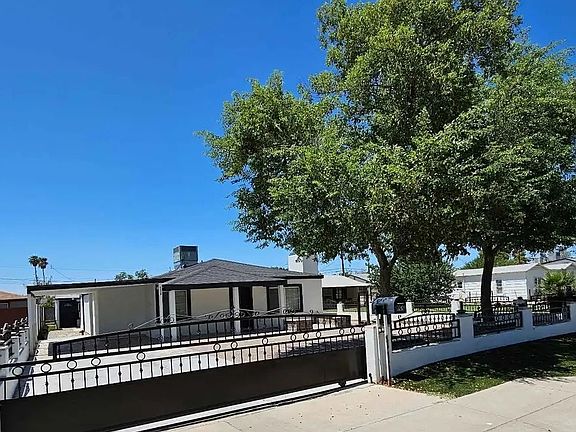 Modern gated property with wide paved entry, mature trees, and excellent curb appeal_offering privacy, comfort, and a welcoming feel in central Phoenix.