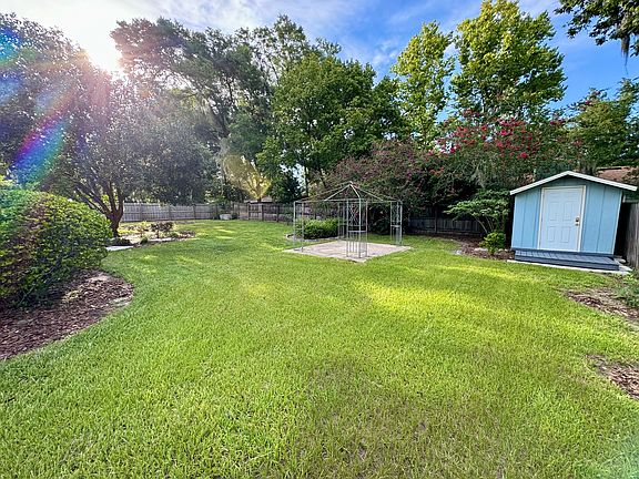 Huge fenced-in backyard with wrought iron gazebo and shed