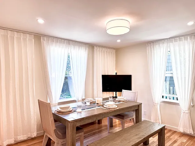 Farmhouse style dining room with tasteful furniture and multiple light sources.