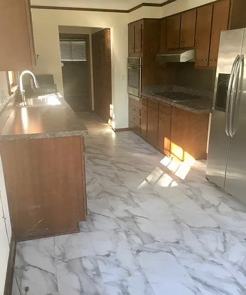 Galley kitchen with porcelain tile floor.