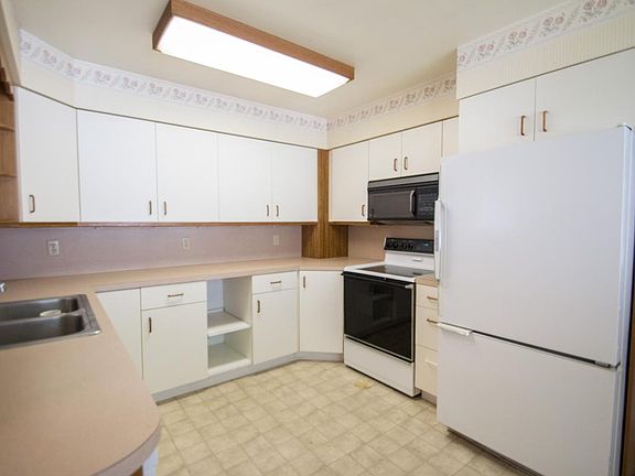 Kitchen with new vinyl flooring, dishwasher, refrigerator