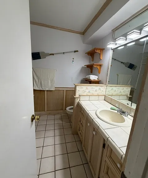bath off hallway features vanity, and excellent lighting