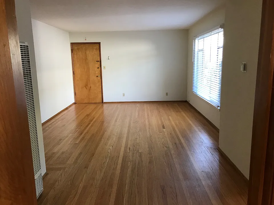 Oversized main room with large window on the right, and front door