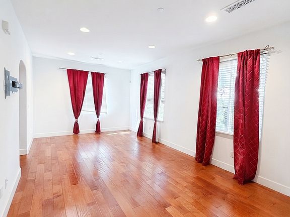 Large family room with rich hardwood flooring and plenty of natural light