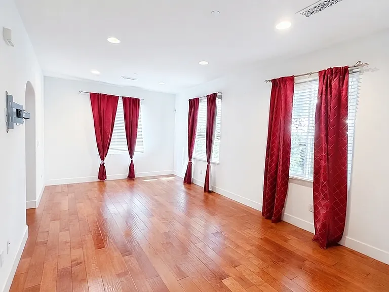 Large family room with rich hardwood flooring and plenty of natural light